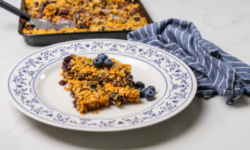 Healthy homemade Blueberry Bars made with Silver Valley Farms blueberries, plated on a white dish with an ornate blue border.